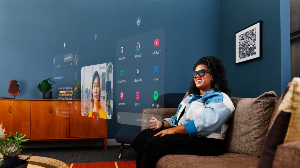 Eine Frau mit AR-Brille von Meta sitzt auf einem Sofa und betrachtet ein transparentes Programmfenster